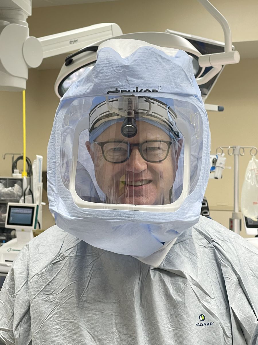 Dr. Olsen in the operating room, wearing a surgical hood and headlight